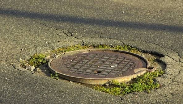 Cast-iron manhole cover set in an asphalt street