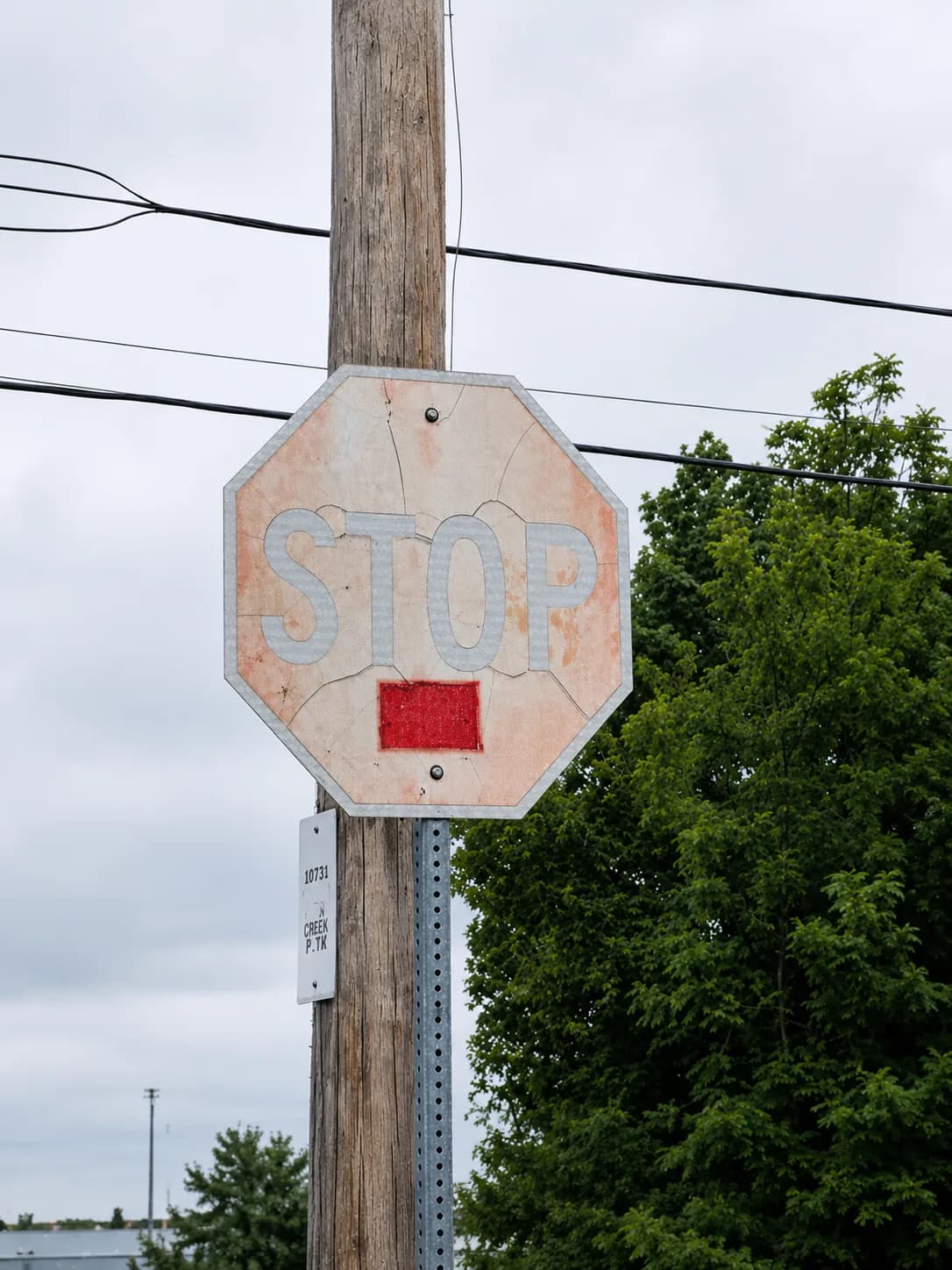 A stop sign with severely faded and cracked reflective sheeting