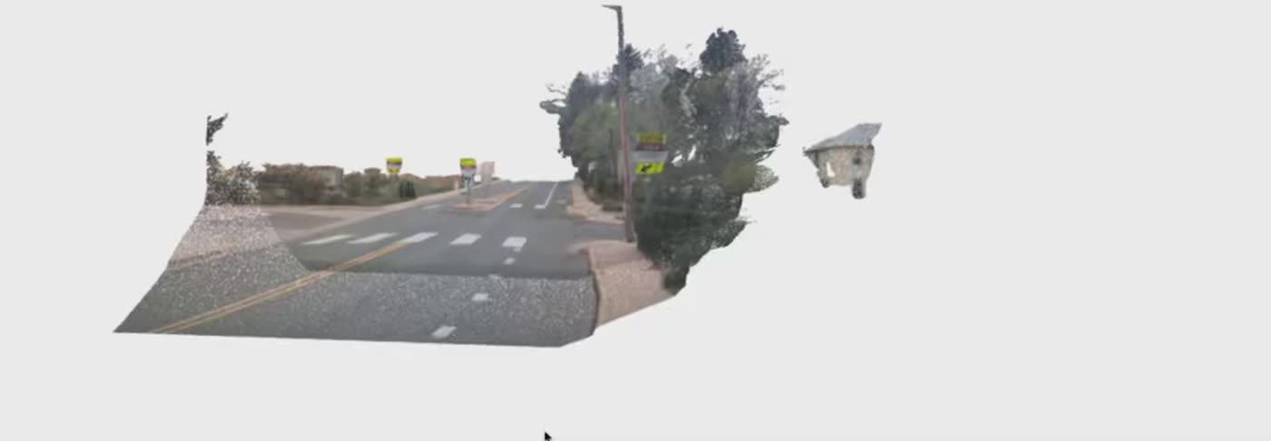 A street corridor rebuilt as a 3D point cloud, orbiting slowly